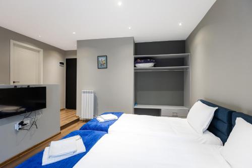 a bedroom with a bed and a flat screen tv at Apart Meidani - Stylish Old Town Apartment with Balcony & Synagogue View in Tbilisi City