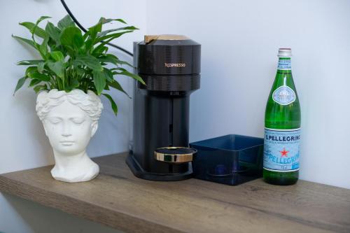 Una botella de cerveza y una planta en un estante. en Celine Apartments, en Piatra Neamţ