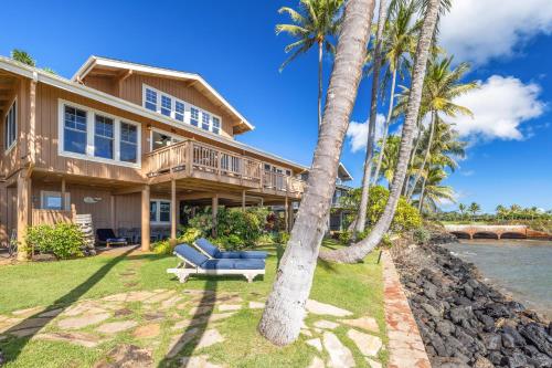 an exterior view of a house with palm trees at Hale Moana in Koloa