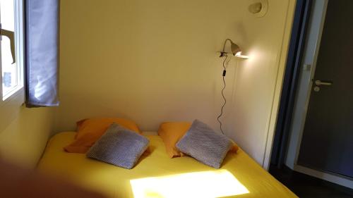 a room with a bed with two pillows and a lamp at Village 17 gites, Piscine, Restaurant , 2 gites avec SPA, 3km de Conques in Conques