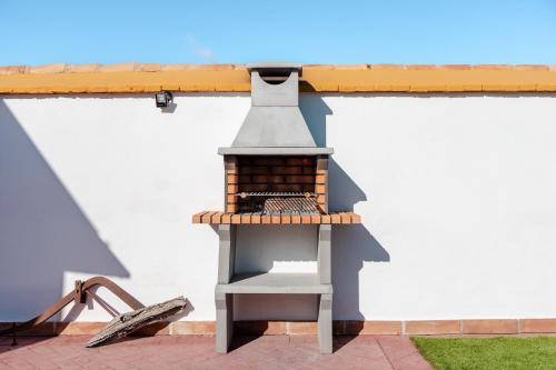 een model van een barbecuegrill aan de zijkant van een gebouw bij Casa rural con piscina, barbacoa, aire acondicionado, WiFi de alta velocidad, cocina exterior y Parking in Córdoba