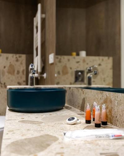 a bathroom with a sink and a counter with two bottles at Apart Meidani - Stylish Old Town Apartment with Balcony & Synagogue View in Tbilisi City
