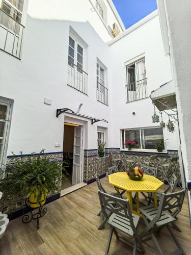 a patio with a yellow table and chairs at Palacete BARSANZ HOME in Alcalá del Valle