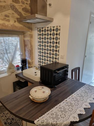 - un four micro-ondes installé sur une table dans la cuisine dans l'établissement La Studette du Pèlerin - Un Air d'Autrefois - Secure & Free Park Vélo -, à Tournus