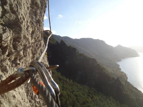 a person on a rope climbing a rock cliff at Villa Carlotta in Crone