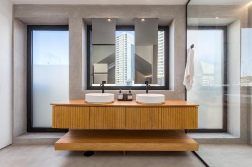 a bathroom with two sinks and a large mirror at Santiago Beach House in Leça da Palmeira