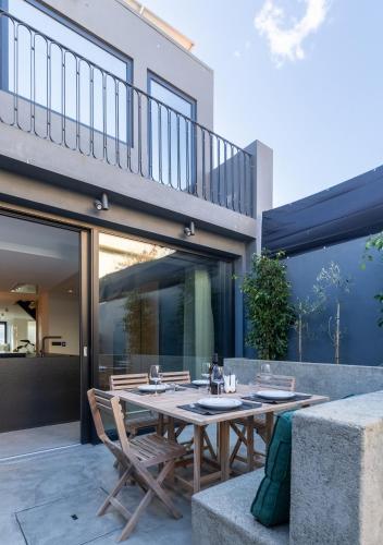 a patio with a wooden table and chairs at Santiago Beach House in Leça da Palmeira