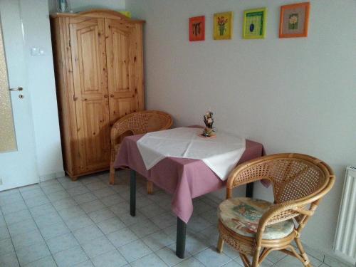 a table with two chairs and a table with a pink table cloth at Pedestrian Street Apartment in Hévíz