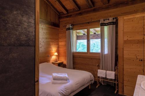 - une chambre avec un lit et une fenêtre dans une cabine dans l'établissement Bois Alpage, à La Chapelle-dʼAbondance