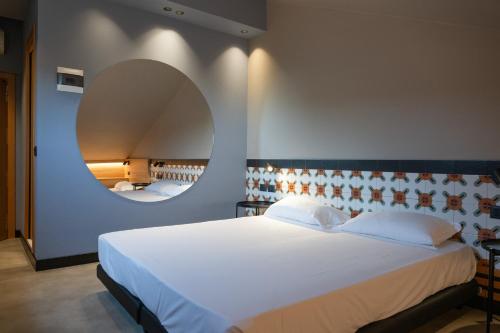 a bedroom with a large white bed and a mirror at Hotel Chery in Milano Marittima