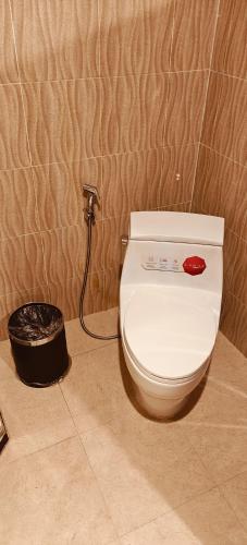 a white toilet in a bathroom with a hose at 欢乐时光精品酒店 in Luang Prabang