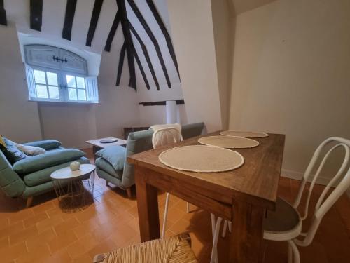un salon avec une table et des chaises en bois dans l'établissement Appartement au centre de Richelieu, à Richelieu