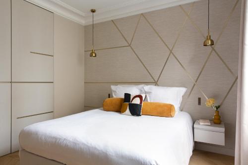 - une chambre dotée d'un lit blanc avec des chaussures dans l'établissement HIGHSTAY - Luxury Serviced Apartments - Arc de Triomphe, à Paris