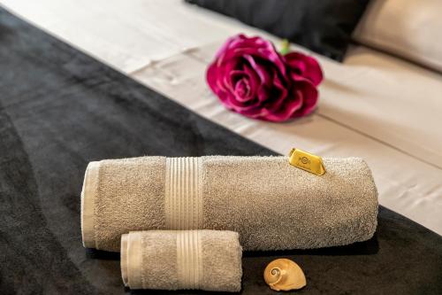 a pink rose sitting next to a towel at saige holidays in Alghero