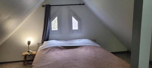 a bedroom with a canopy bed with a window at Village 17 gites, Piscine, Restaurant , 2 gites avec SPA, 3km de Conques in Conques