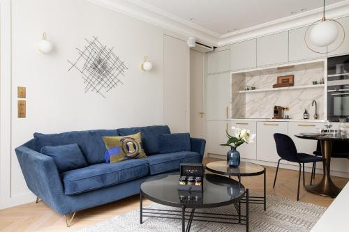 un salon avec un canapé bleu et une table dans l'établissement HIGHSTAY - Luxury Serviced Apartments - Arc de Triomphe, à Paris