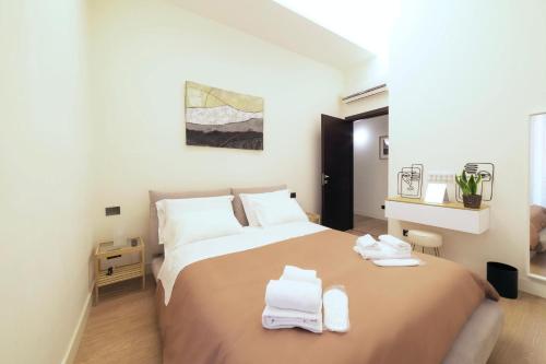 a bedroom with a large bed with two towels on it at Guli's Suite - Lusso e Comfort in Centro Storico in Naples