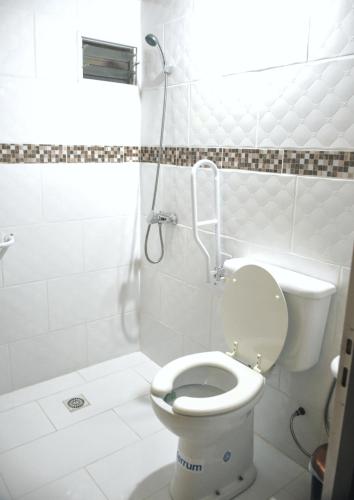 a white bathroom with a toilet and a shower at LORETO GUEST HOUSE YAYETOPa in Loreto