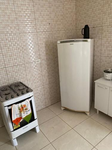 a kitchen with a stove and a refrigerator at Espaço Amplo de 2 quartos com 2 camas de casal e 1 de solteiro in Juazeiro do Norte