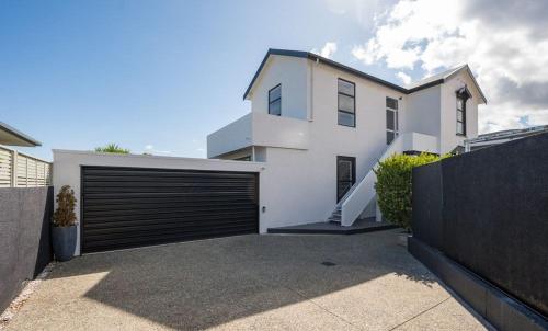 a large white house with a garage door at Guest House on Grove - short walk to Nelson city centre in Nelson