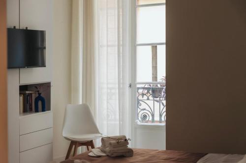 a bedroom with a chair and a window at Guli's Suite - Lusso e Comfort in Centro Storico in Naples