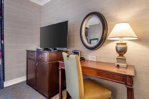a room with a desk with a television and a mirror at Omni Shoreham Hotel in Washington