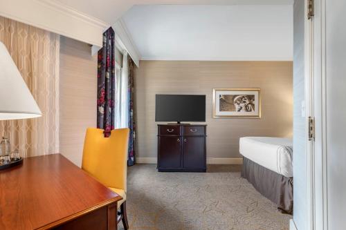 a hotel room with a bed and a desk and a television at Omni Shoreham Hotel in Washington