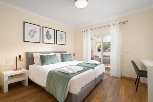 a bedroom with a large white bed with a desk at Modern and Spacious Holiday Apartment, Cabanas in Cabanas de Tavira