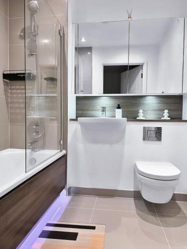 a bathroom with a toilet and a sink and a shower at Luxury 2-Bedroom London Apartment, 25mins to Liverpool Street, Balcony, Free Parking in London