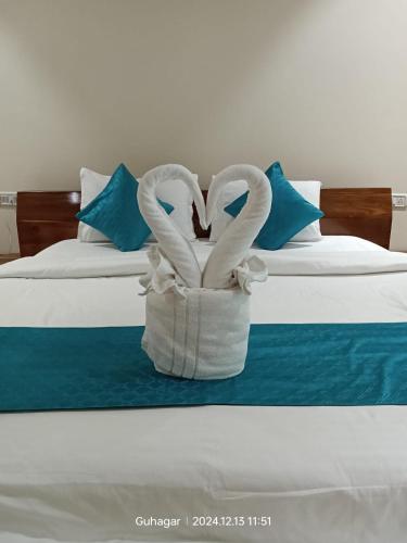two swans in a basket on a bed at Shantadurga Beachside Homestay in Guhagar