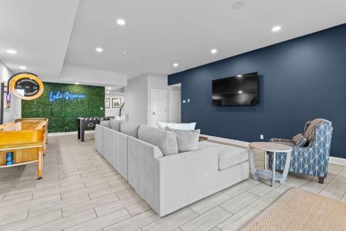 a living room with a couch and a tv on a blue wall at Lake Escape by AvantStay Lakefront Private Dock in Mooresville