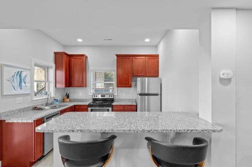 a kitchen with a marble counter top and wooden cabinets at Lake Escape by AvantStay Lakefront Private Dock in Mooresville