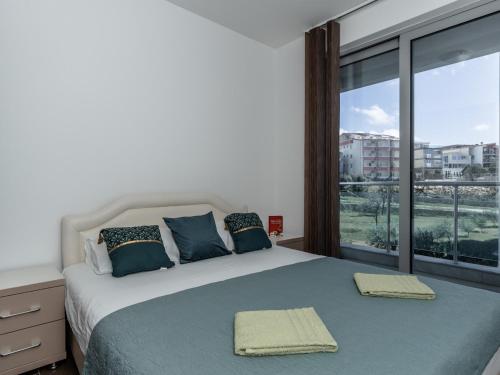 a bedroom with a bed with a large window at Apartments 4U in Dobra Voda