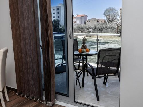 a balcony with a table and a glass door at Apartments 4U in Dobra Voda