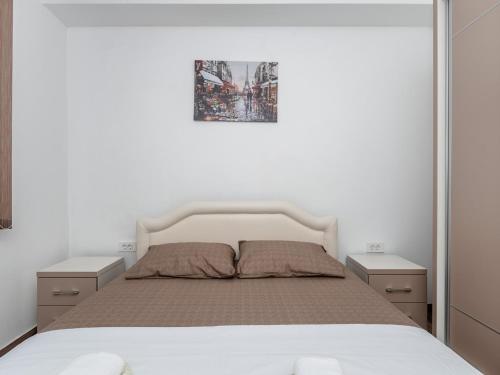 a bedroom with a white bed with two night stands at Apartments 4U in Dobra Voda