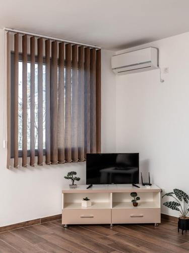 a living room with a flat screen tv on a white wall at Apartments 4U in Dobra Voda