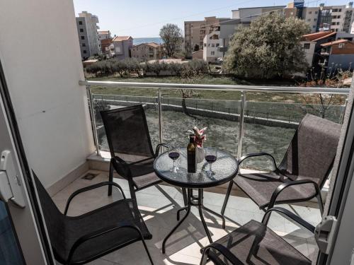a table and chairs on a balcony with a view at Apartments 4U in Dobra Voda