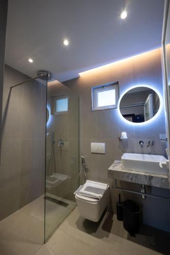a bathroom with a toilet and a sink and a mirror at Mariksel HOTEL in Ksamil