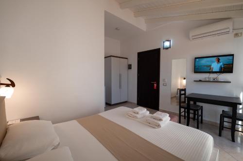 a bedroom with a bed and a desk and a television at Mariksel HOTEL in Ksamil