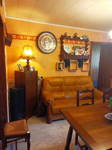 un salon avec un canapé et une horloge au mur dans l'établissement chambreallouagneeddy, à Allouagne