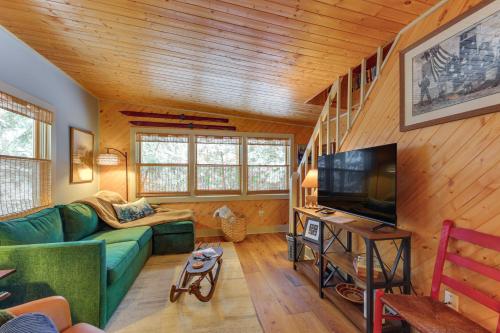 ein Wohnzimmer mit einem grünen Sofa und einem TV in der Unterkunft Steps to Lake, 2 Mi to Slopes Cozy Okemo Cabin in Ludlow