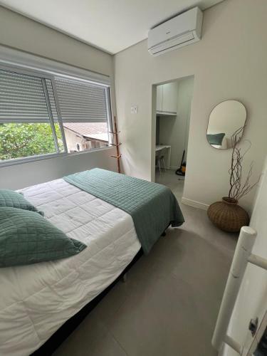 a bedroom with a bed and a large window at Casa familiar - Refúgio Climatizado in Florianópolis