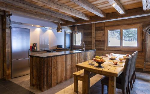 une cuisine avec une table en bois et un réfrigérateur dans l'établissement Bois Mazot, à La Chapelle-dʼAbondance