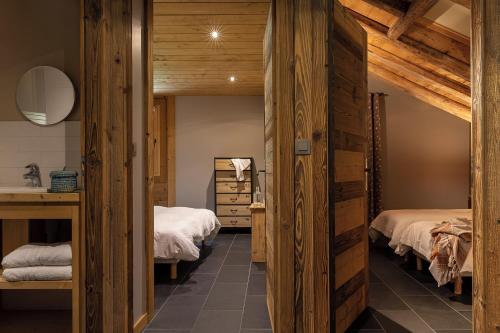 une chambre avec deux lits et un lavabo dans l'établissement Bois Mazot, à La Chapelle-dʼAbondance
