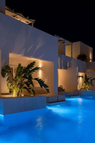 a swimming pool at night with blue lights at Heyday Luxury Suites in Perissa