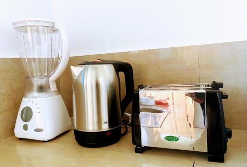 a blender sitting next to a counter next to a food processor at La Casa De Papel Morogoro Apartment by Monalisa in Morogoro