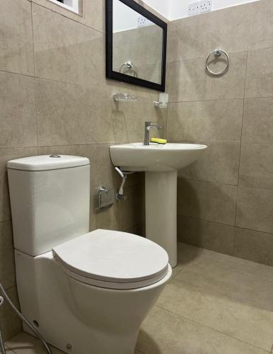 a bathroom with a white toilet and a sink at The Glory Villa Transit Hotel in Katunayake