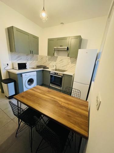 une cuisine avec une table en bois et un réfrigérateur dans l'établissement Appartement Californie Beach, à Nice
