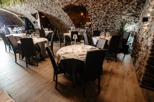 a dining room with tables and chairs and a brick wall at Il Cervo Chambres d'hôtes in Aosta