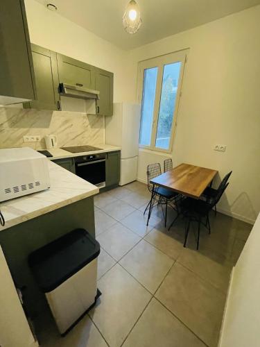 une cuisine avec une table et des chaises dans une pièce dans l'établissement Appartement Californie Beach, à Nice